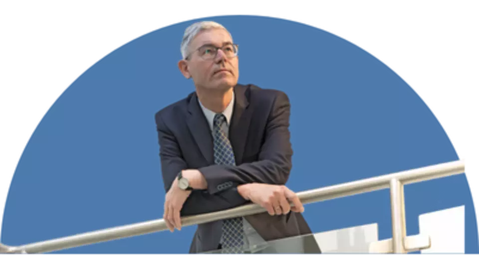 CEO Peter Giffinger lehnend an einem silbernen Geländer